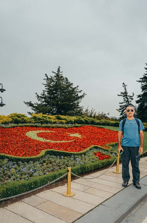turista-jardim-bandeira-turquia-ankara Homem em pé ao lado de jardim ornamental com o desenho da bandeira da Turquia.