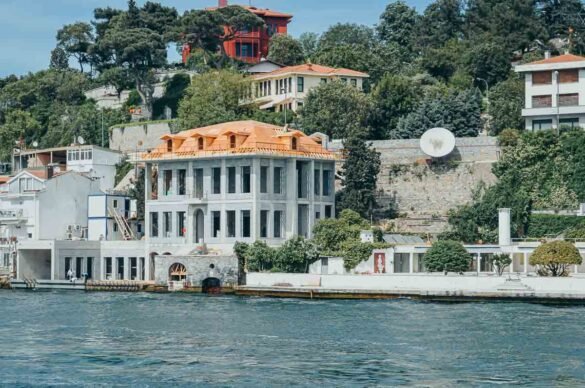 Casas de luxo e uma mansão em construção nas colinas verdes à beira-mar.