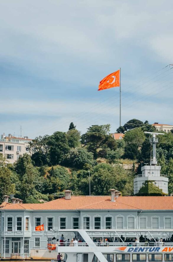 Bandeira da Turquia hasteada acima de um barco de passageiros no Estreito de Bósforo.