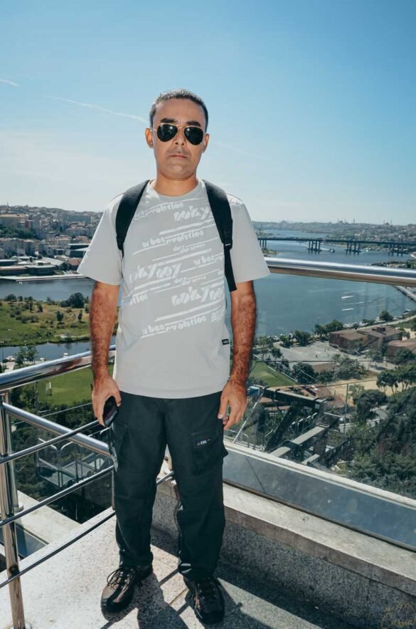 Homem de óculos escuros em mirante com vista panorâmica para o Chifre de Ouro em Istambul.