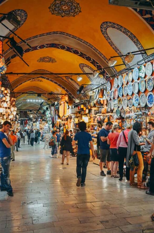 Loja no Grande Bazar exibindo pratos de cerâmica coloridos e luminárias turcas penduradas.