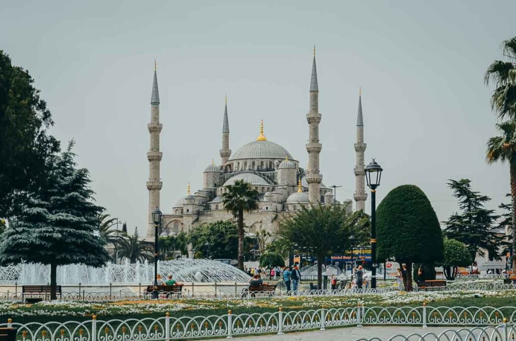 Vista externa da Mesquita Azul com seus seis minaretes e cúpulas sob um céu claro em Istambul.