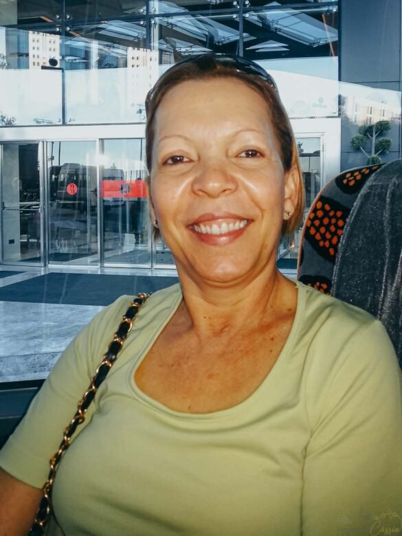 Close-up de mulher sorrindo sentada em um ônibus ou saguão durante viagem à Turquia.