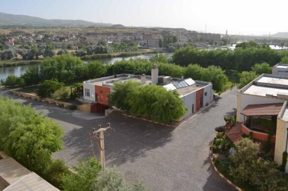 vista-rio-kizilirmak-avanos-capadocia Vista elevada do Rio Vermelho em Avanos, Turquia, com casas e vegetação ao redor.