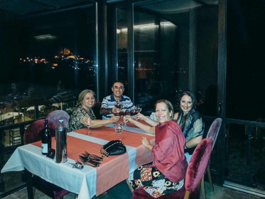 Grupo brindando com vinho em restaurante à noite na Capadócia.