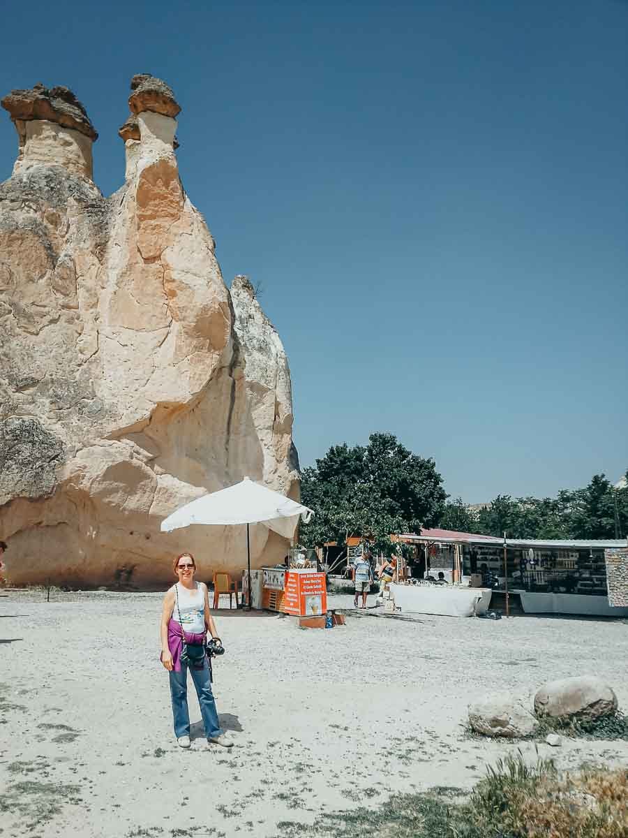 turista-visitando-chamine-fada-cappadocia Visitante posando próximo a chaminés de fada na Capadócia.