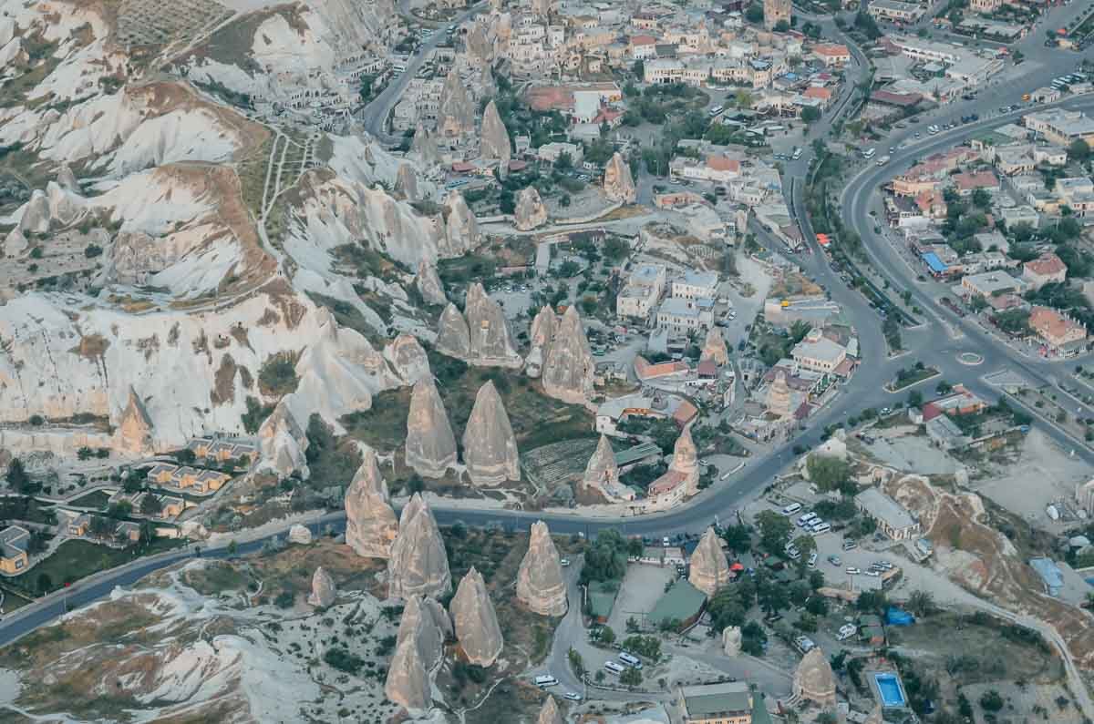 vista-aerea-cidade-chamines-fada-capadocia Vista aérea de uma cidade na Capadócia com casas construídas entre as formações rochosas conhecidas como chaminés de fada.