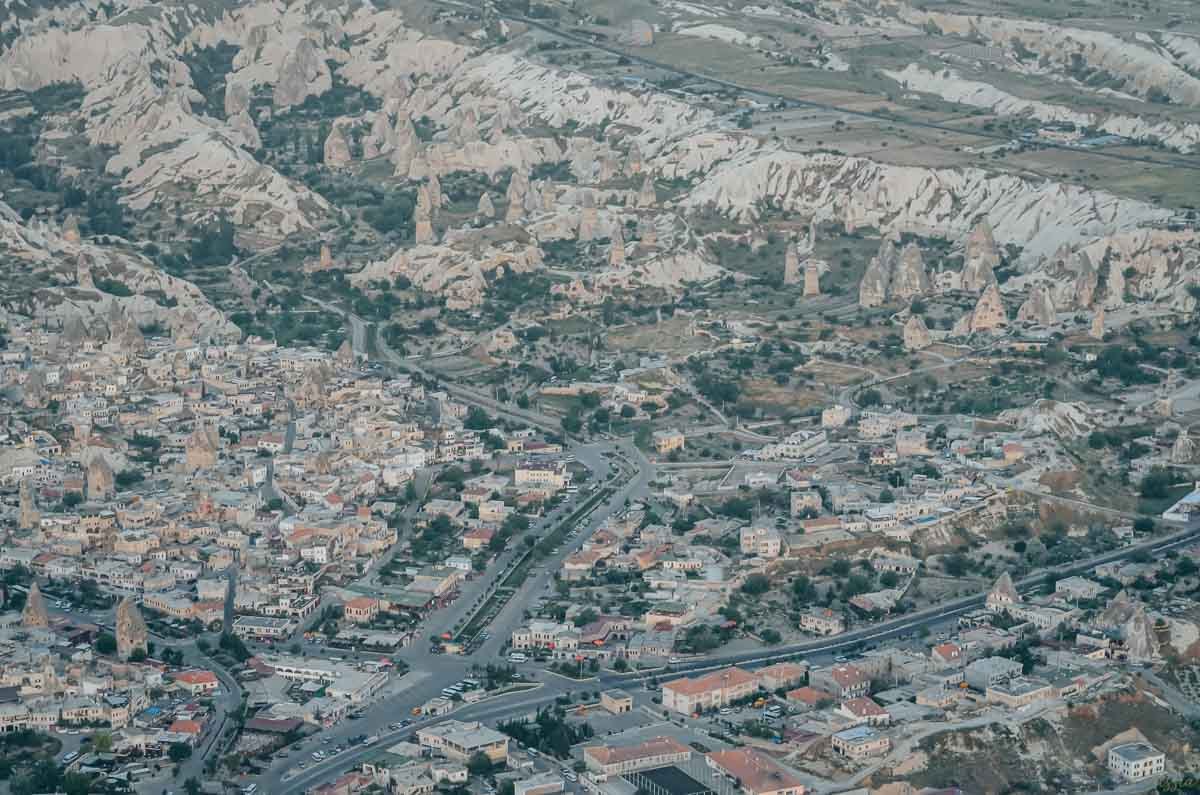 vista-aerea-cidade-formacoes-rochosas-capadocia Vista aérea de uma cidade na Capadócia com formações rochosas pontiagudas.