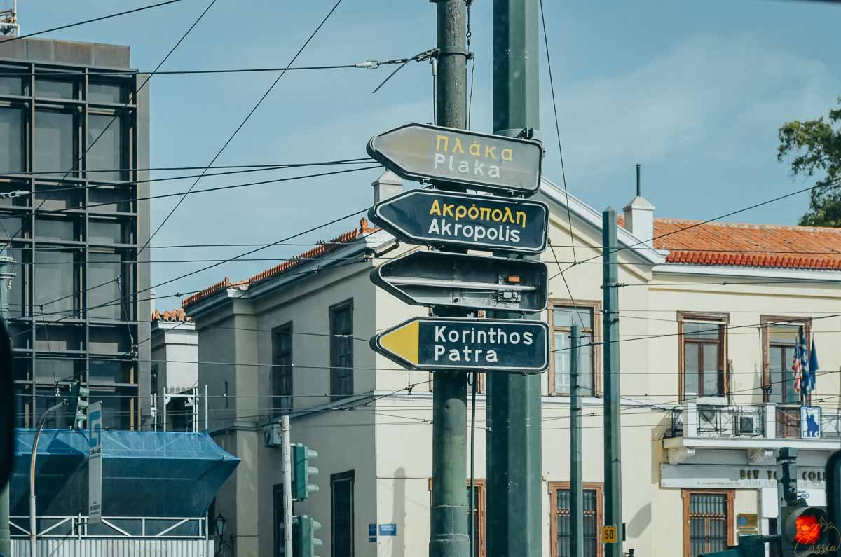placas-sinalizacao-plaka-acropole-atenas Placas de trânsito em poste apontando direções para os bairros Plaka e Acrópole em Atenas.
