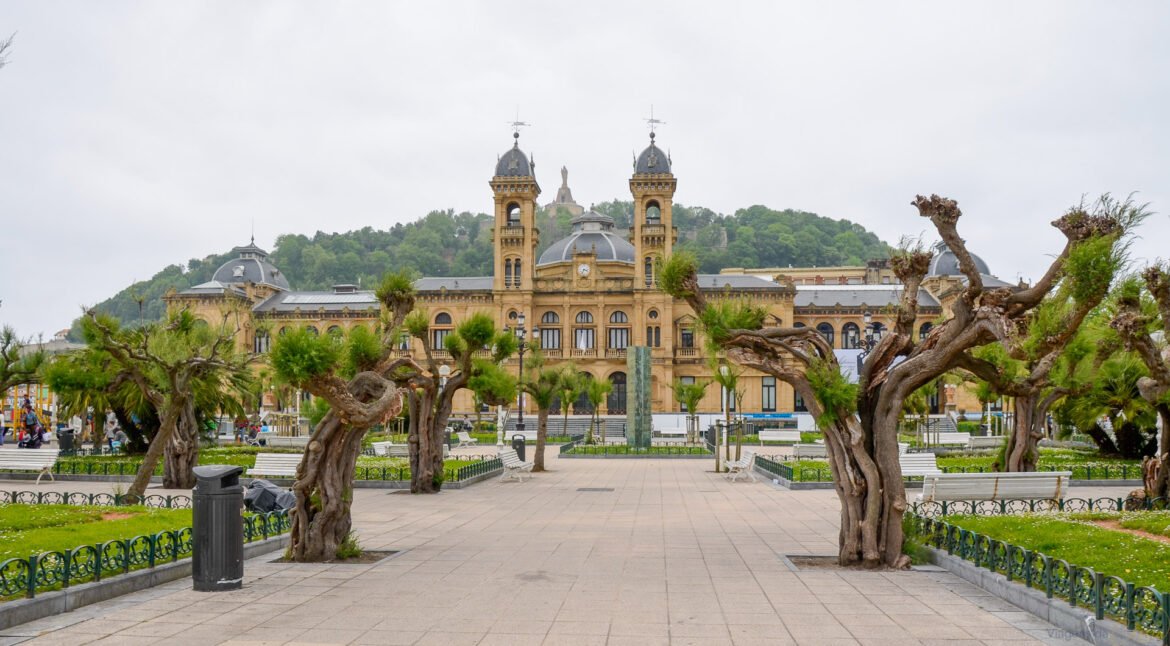 Fachada do imponente prédio da Prefeitura de San Sebastián vista a partir da praça arborizada.