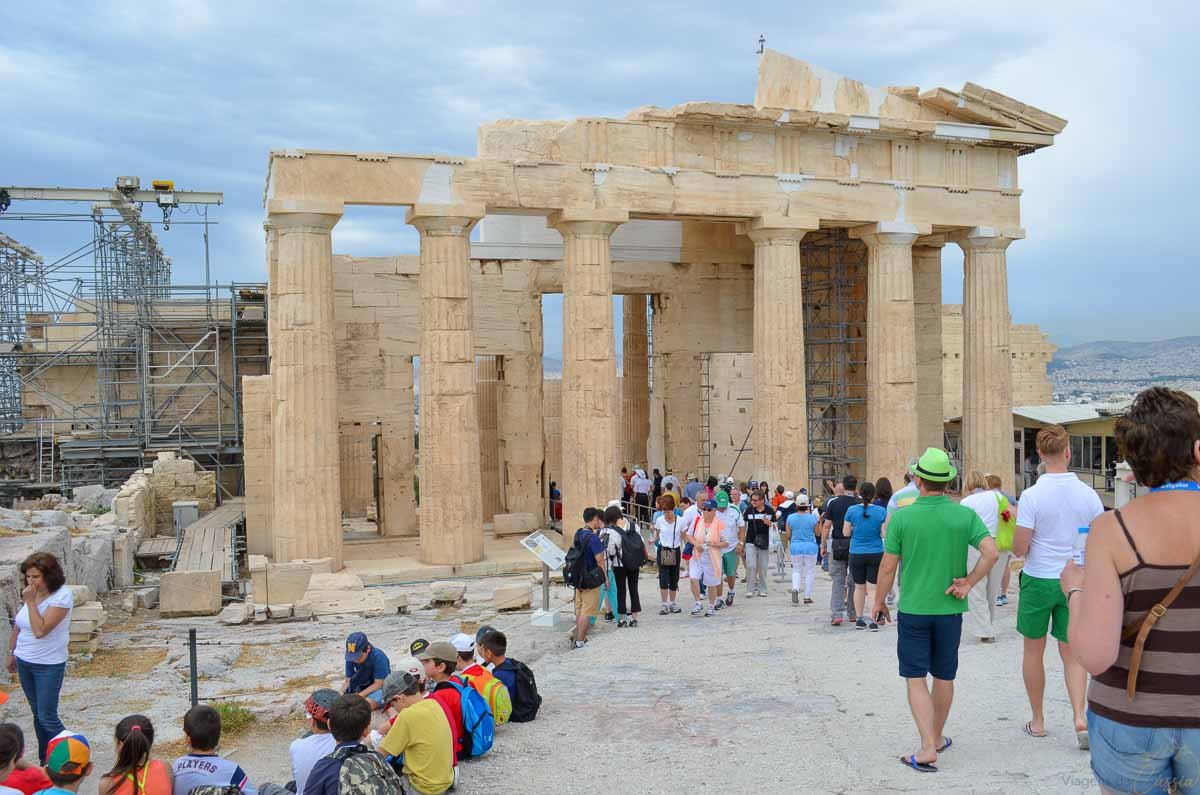 turistas-portico-propileus-acropole-atenas Visitantes e grupos escolares reunidos no amplo pátio dos Propileus no topo da Acrópole.
